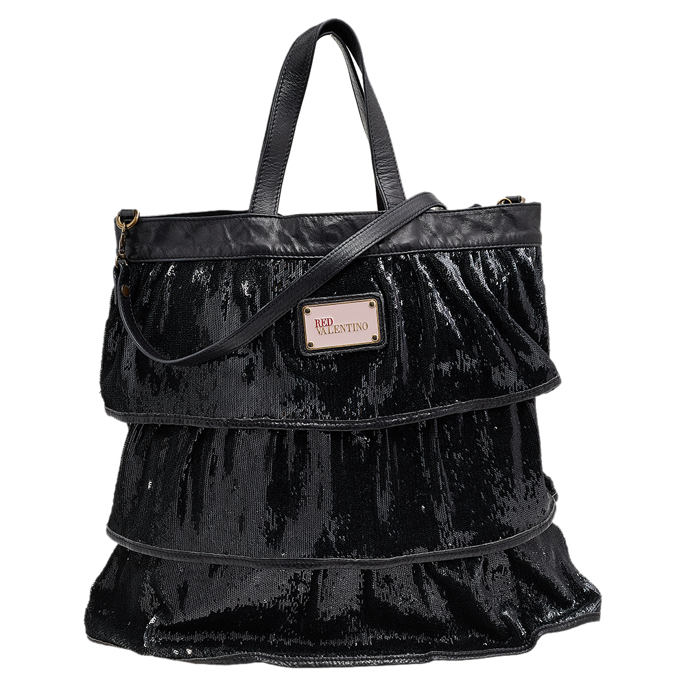 This stunning creation from RED Valentino is sure to add some bling to your outfit. Crafted from black sequins the bag features two handles and a shoulder strap. The zip top closure opens to a canvas lined interior that will hold all your party essentials.