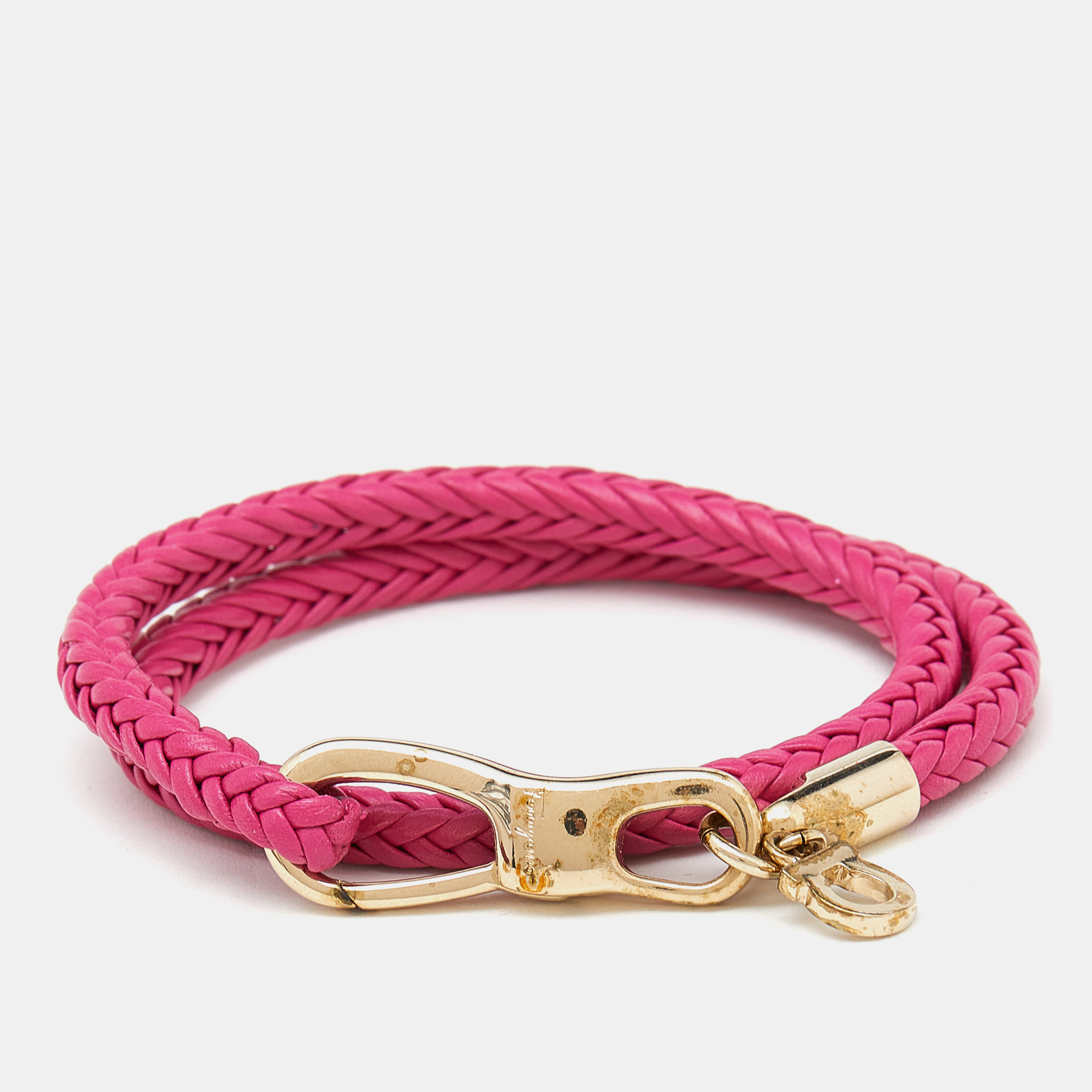 Artfully made from braided leather and gold tone metal this flawless bracelet by Salvatore Ferragamo can be your next prized possession. It features the signature Gancio motif a pink hue and logo detailing. it is finished with a lobster clasp.