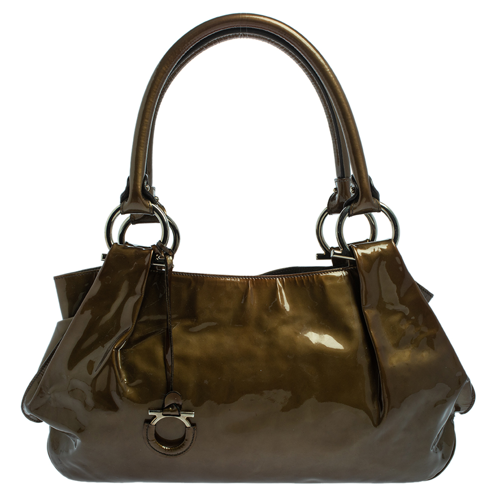 Crafted in patent leather this bag is sure to make an amazing style statement. This fine nylon lined interior can easily accommodate all your essentials. Stay updated in contemporary fashion by bringing home this shoulder by Salvatore Ferragamo. Coming in an olive green shade the creation is complete with a Gancini motif charm.
