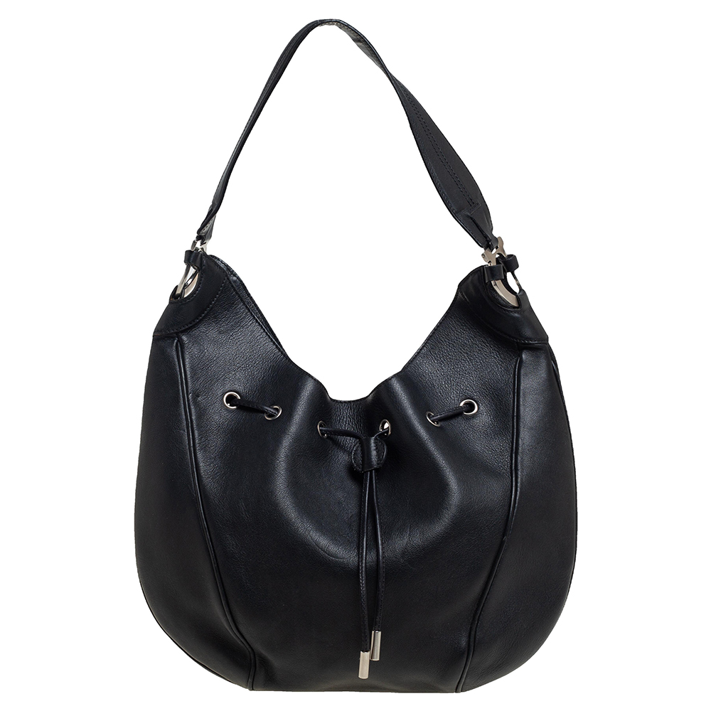 This hobo from Salvatore Ferragamo is crafted from leather in a black hue. It has a drawstring closure that opens to a canvas lined interior. Feminine in design the bag is perfect for everyday use.