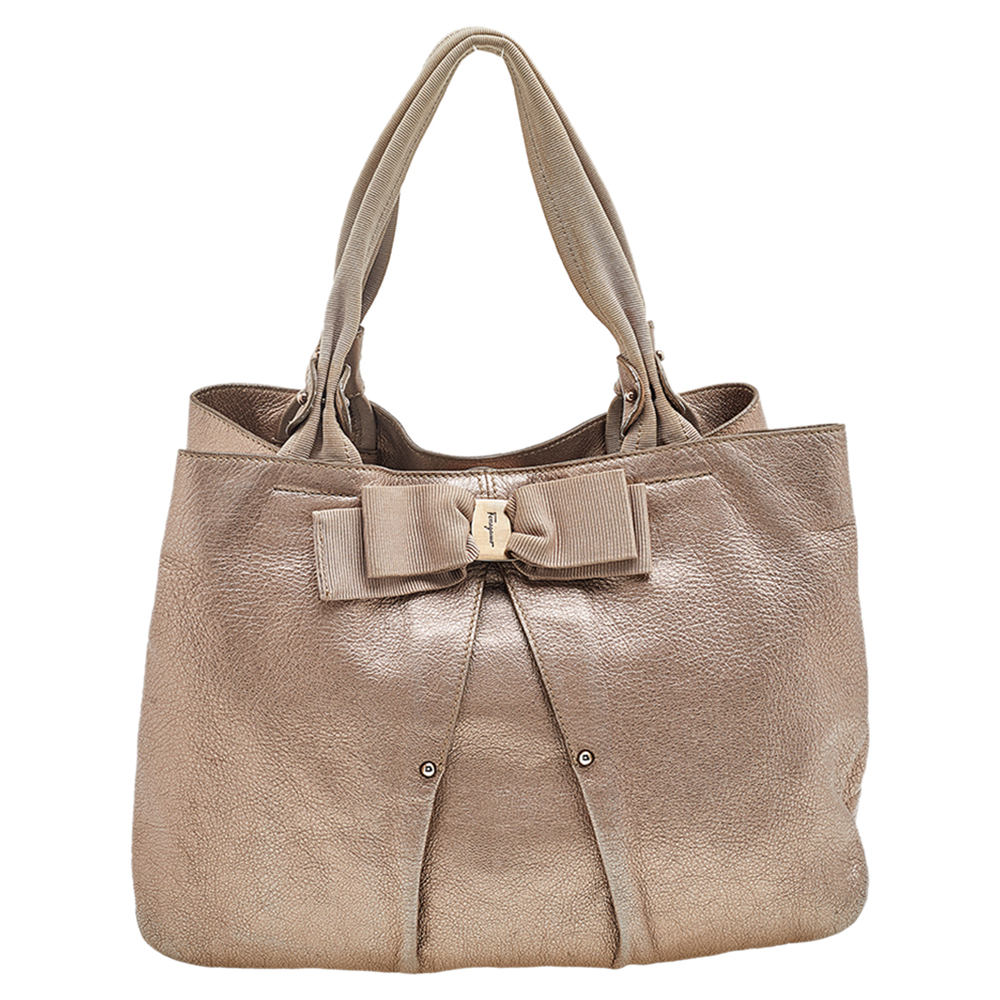 Crafted from leather this metallic bronze Salvatore Ferragamo tote has a Vara Bow detail two handles and a spacious fabric interior. Swing this beauty on your busy days.