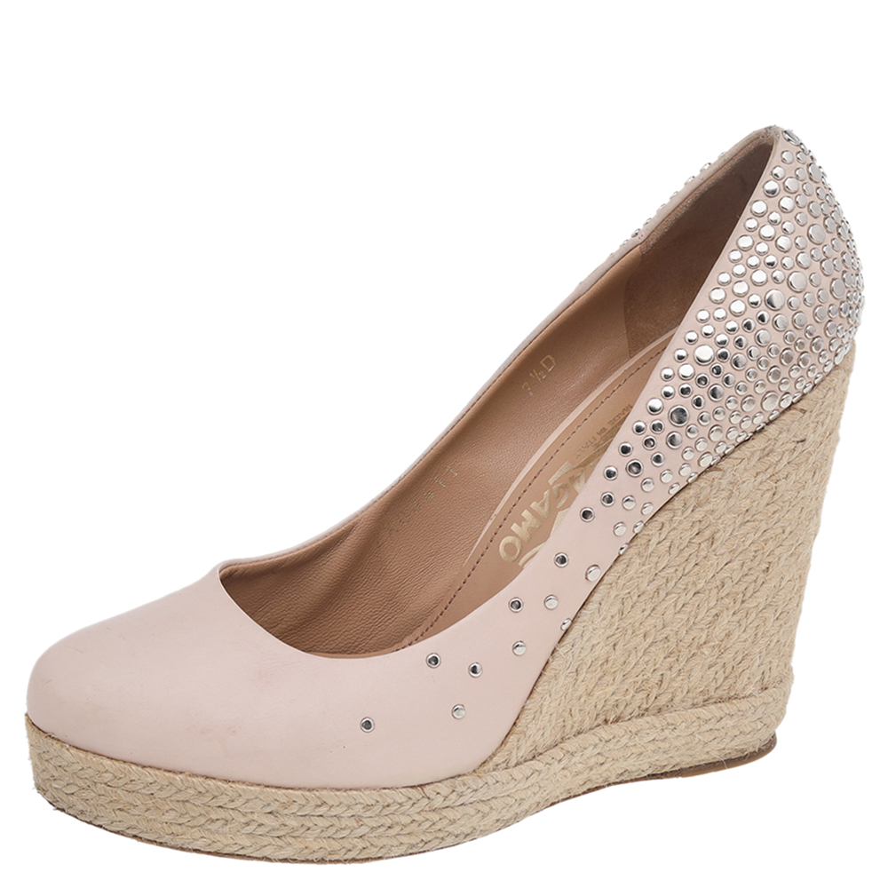 Impeccably crafted in Italy and showcasing exemplary craftsmanship these pumps by Salvatore Ferragamo in beige leather feature round toes crystal embellishments and espadrille wedge heels. Let them show under cropped hemlines for an elegant take.