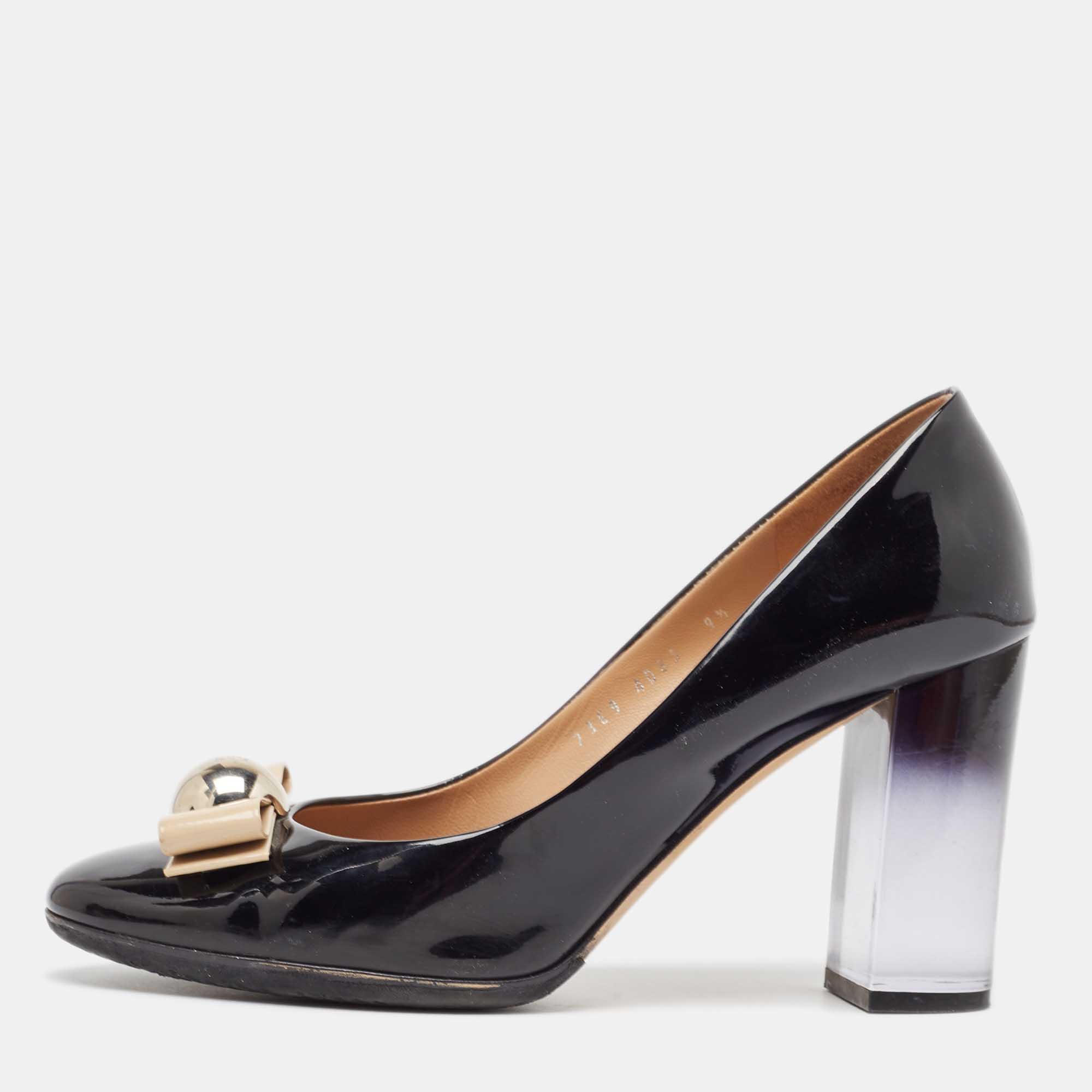 What beauty are these pumps from Salvatore Ferragamo Carrying a shiny black exterior they are crafted from leather and styled with a bow detail on the uppers. Theyll help you stand tall with the 10cm block heels made from plexiglass.