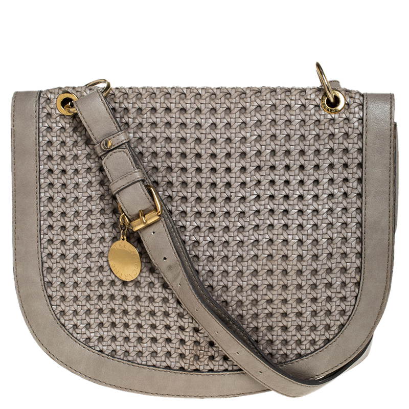Carry this bag from Stella Mc Cartney without compromising on style. This woven leather bag comes in a U shape with a flap. This chic grey bag opens to a leather lined interior and is held by a shoulder strap.