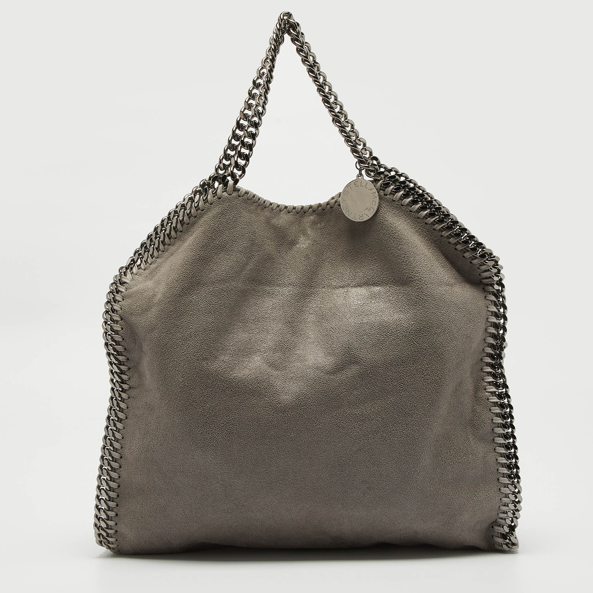 The chain whipstitch detailing beautifully outlines this Stella Mc Cartney Falabella tote. Crafted from faux leather it has been adorned with silver tone accents and it can be carried with dual chain handles at the top. The fabric lined interior can safely store your essentials.