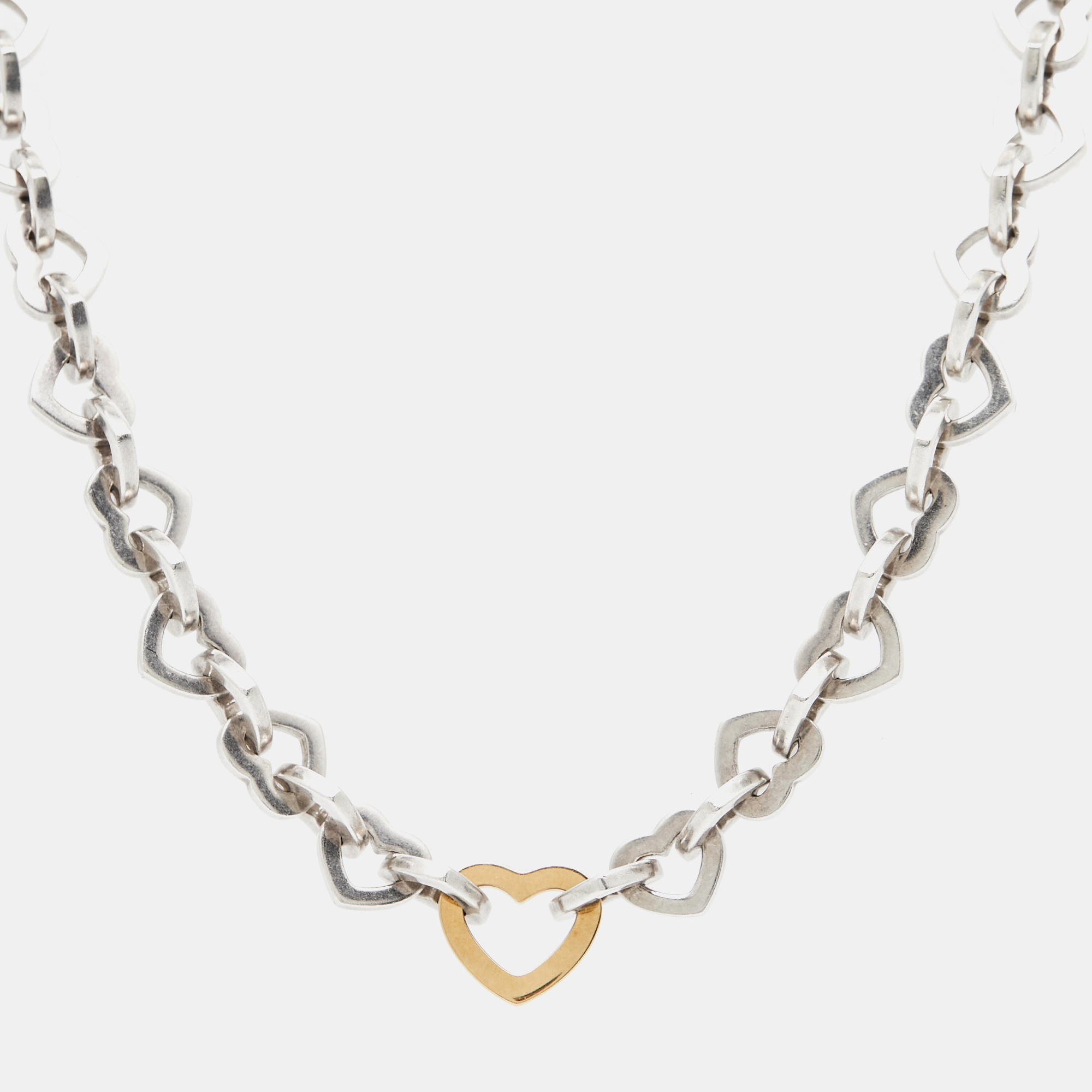 Presenting the exquisite Tiffany and Co. necklace a stunning blend of sterling silver and 18k yellow gold. This captivating piece exudes timeless charm with its heart design symbolizing love and connection. Elevate your style effortlessly with this elegant accessory perfect for any occasion.