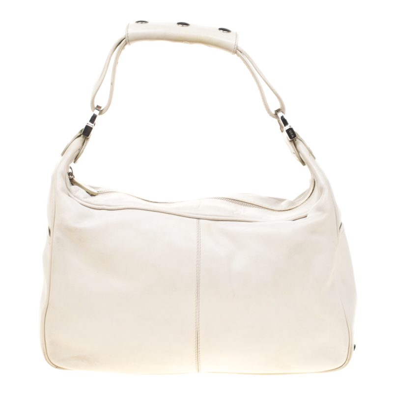 Tods hobo is ideal for everyday use. The bag is crafted from off white leather and features two slip pockets on each side. The top zip closure opens to a fabric lined interior that houses a zip pocket and the bag is complete with a shoulder strap.