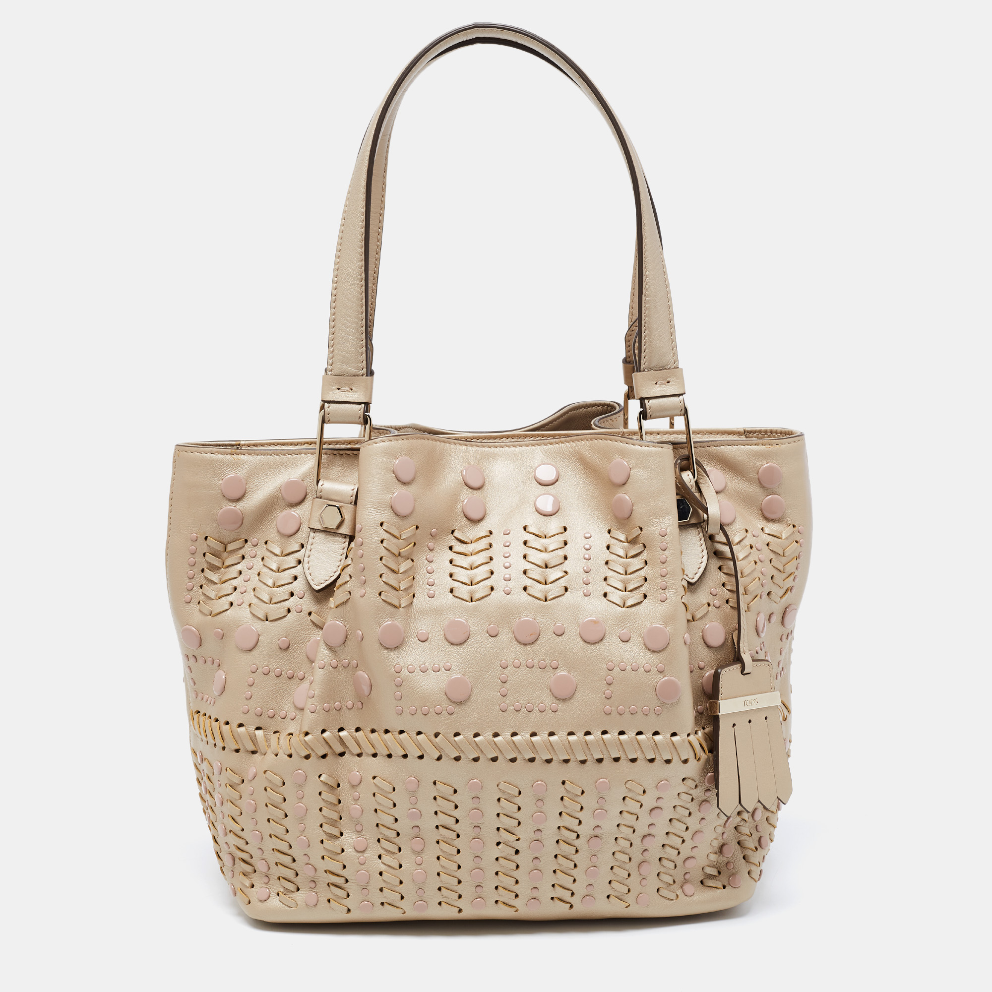 Tods delivers a beautifully made tote in beige leather to assist you to lunch or shopping. This lovely tote is decorated with studs and sized spaciously for neatly housing your belongings. Two handles on top allow easy carrying options.