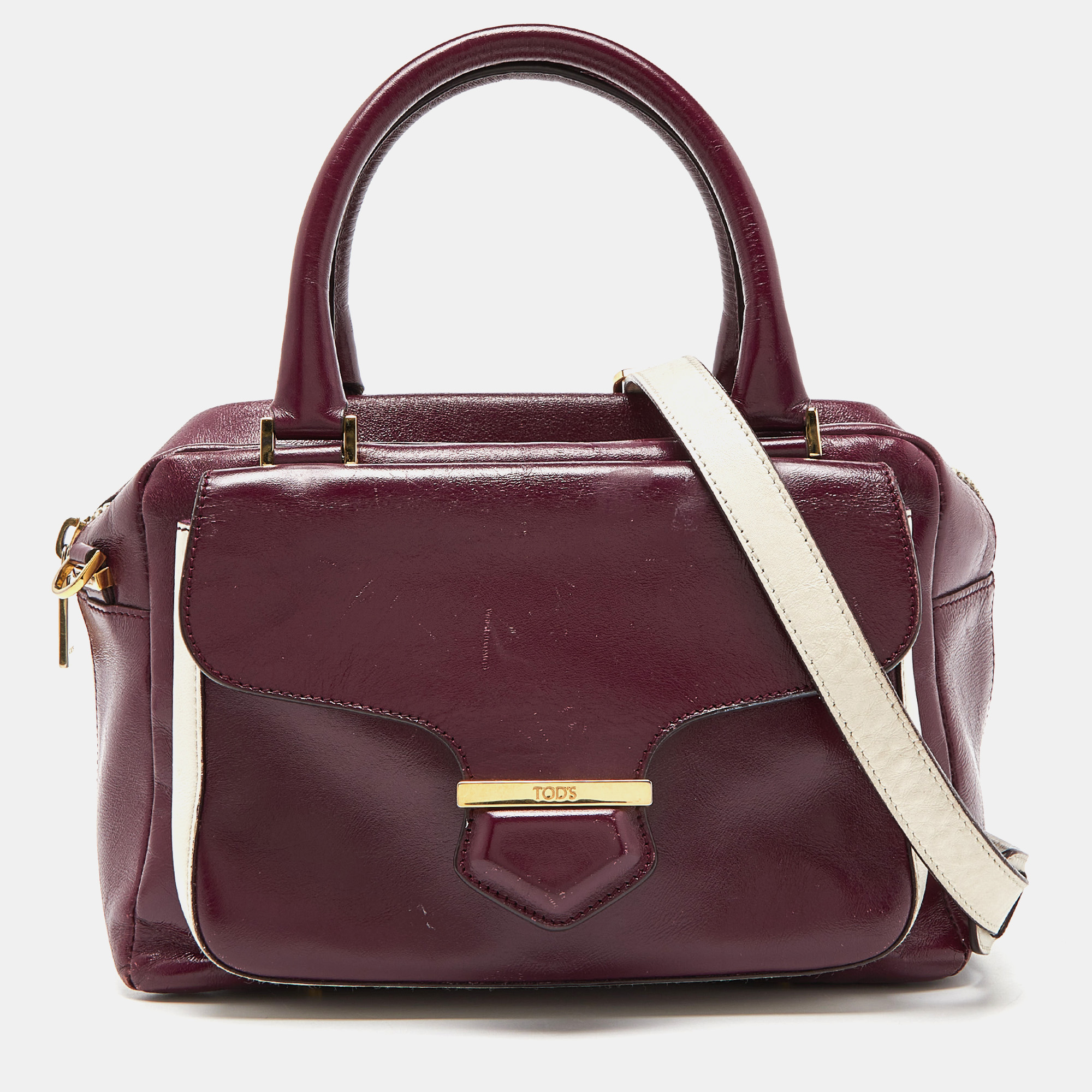 This Bowler bag from Tods is simple in design but high on style. Crafted from glossy leather the bag features double top handles a shoulder strap and protective feet at the bottom. It has an exterior flap pocket and a top zipper reveals a fabric interior for your necessities. The bag is truly a luxe addition to your style.