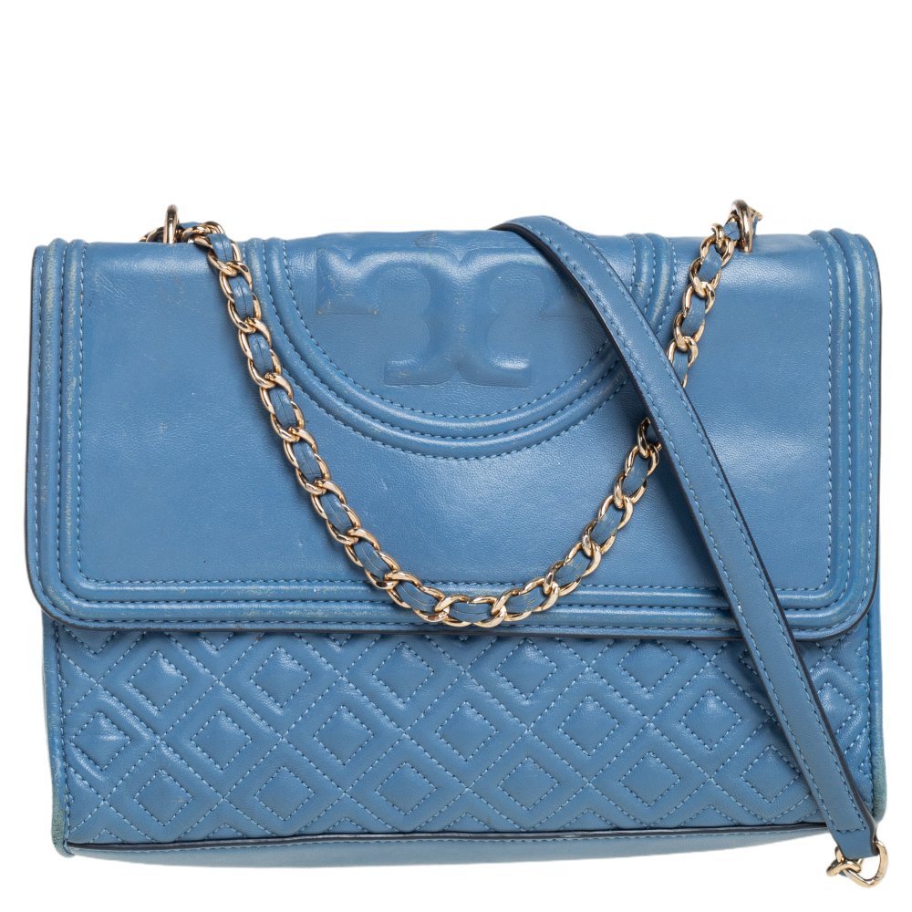 This Fleming shoulder bag from Tory Burch has been meticulously crafted from quilted leather in a dreamy blue hue. The flap opens to a fabric lined interior and the bag is held by an interwoven chain link. This is a stylish bag made for any occasion.