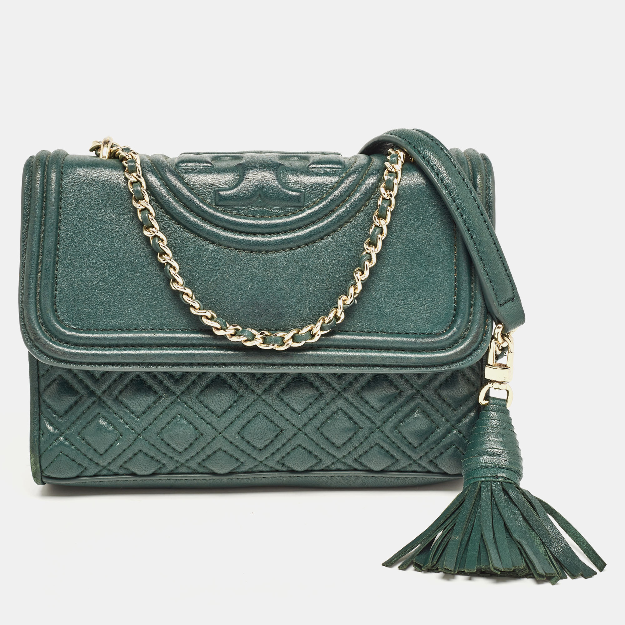 This Fleming shoulder bag from Tory Burch has been meticulously crafted from leather in a dreamy hue and designed with quilts in diamond patterns and the logo on the top. The flap opens to a fabric lined interior and the bag is held by an interwoven chain link accented with a tassel. This is a marvelous bag made just for you.