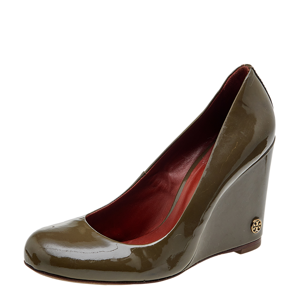 These olive green pumps from Tory Burch are simple but a must have. Crafted using patent leather and balanced on 10 cm wedges the round toe pumps are complete with the brand logo on the heels. They are high in both style and comfort.