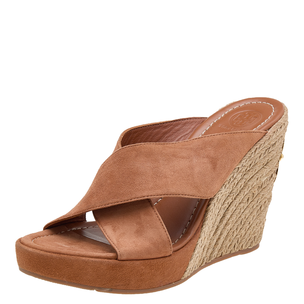 Take your style a few notches higher with these sandals from Tory Burch. Crafted from brown suede and styled with open toes they have criss cross straps and 12 cm wedge heels. Theyll look great with your casual outfits.