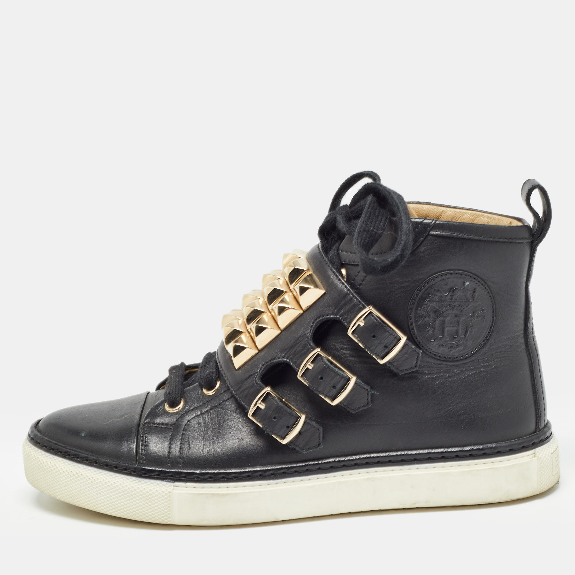 Pull off a super stylish look with ease in this pair of black high top sneakers from the house of Hermes. Crafted from leather the Lennox shoes truly embody luxury and comfort with their unique studded design. They feature lace ups gold tone buckles leather insoles and tough soles. A statement pair worthy of being flaunted