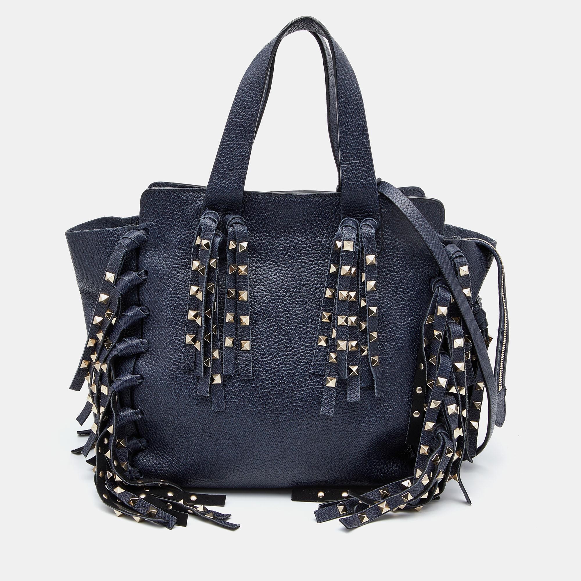 Every modern day wardrobe needs a Valentino tote like this. Get this beautiful leather bag featuring a lovely touch of fringe details covered with the signature Rockstuds. It is complete with a capacious interior that can easily house your belongings. Pair this remarkable piece with dresses and coats.