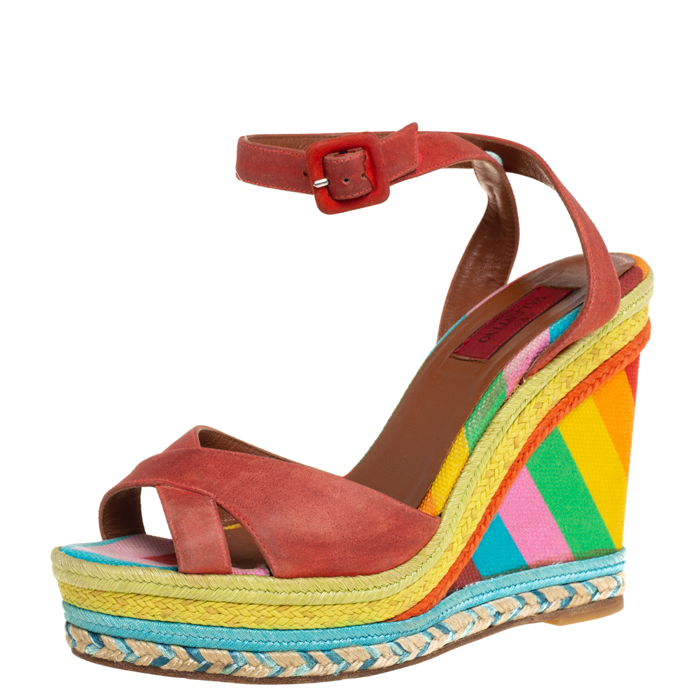 These vibrant sandals from Valentino are stylish and comfortable at the same time. They are crafted from red suede and designed with criss cross vamp straps buckled ankle straps and leather lined insoles. They are elevated on 12 cm colorful espadrille wedge heels.