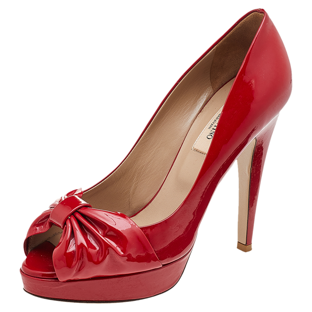 Exude poise and perfection as you walk in these pumps from the House of Valentino. They are crafted using red patent leather on the exterior with a bow motif attached to the peep toes. They are raised on 12 cm heels. Make a stunning style statement as you wear these pumps