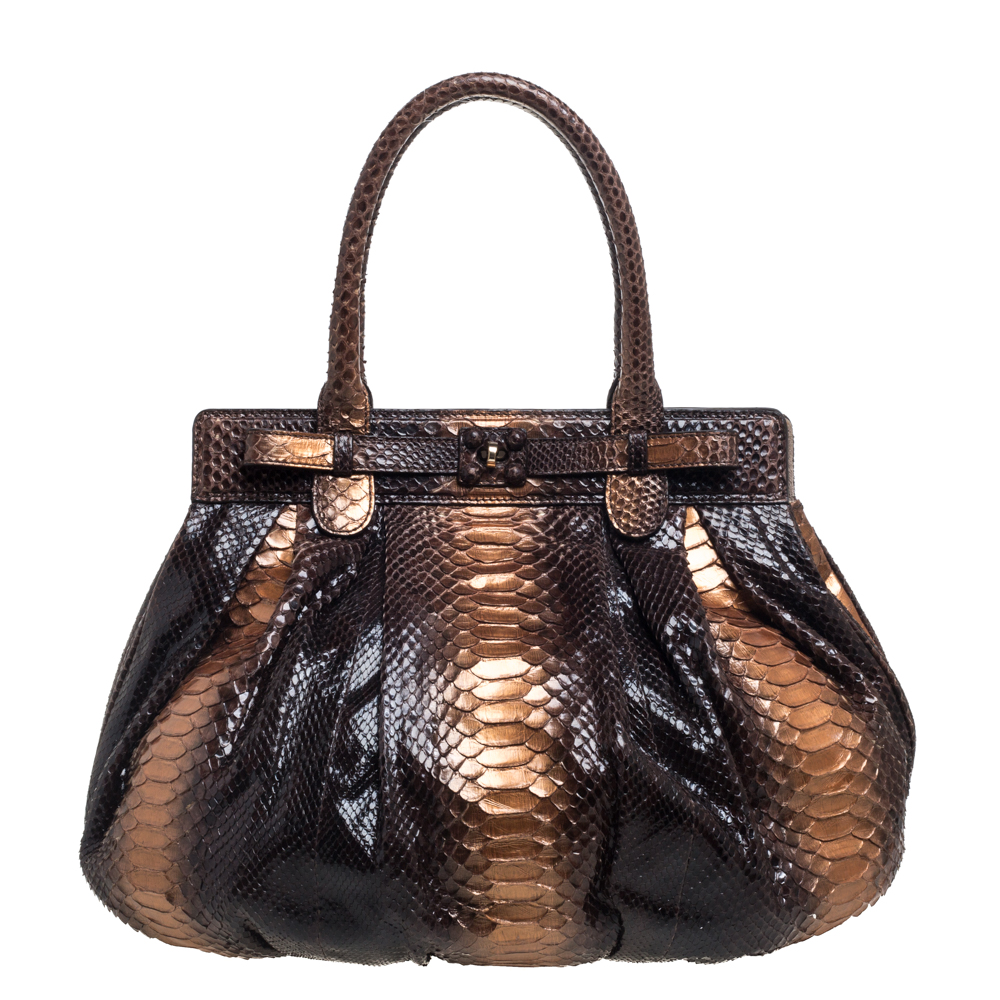 This Zagliani Puffy has all the details that make a bag prized. The bag has been crafted by hand from python leather and lined with suede on the insides. It has gold tone hardware and two top handles for you to easily parade it. The grand metallic hues that cover its expanse just add more to its appeal and make it a truly priceless collectible. NOTE: AVAILABLE FOR UAE CUSTOMERS ONLY