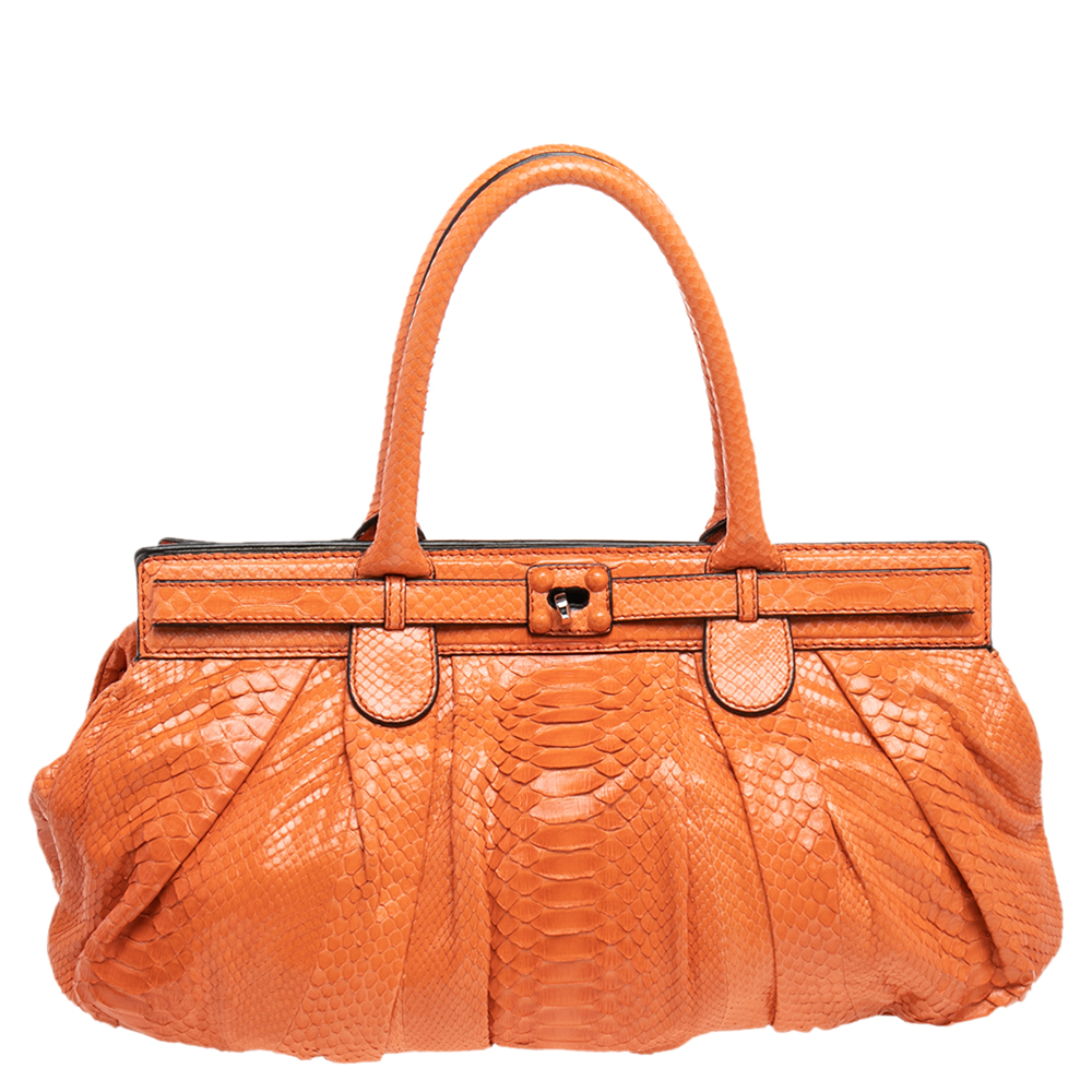 Make a fine investment with this Zagliani creation. It has been crafted using python leather and lined with suede on the insides. It has silver tone hardware and two top handles for you to parade it easily. The grand orange hue covering its exterior adds to its appeal and makes it a truly priceless collectible. NOTE: AVAILABLE FOR UAE CUSTOMERS ONLY